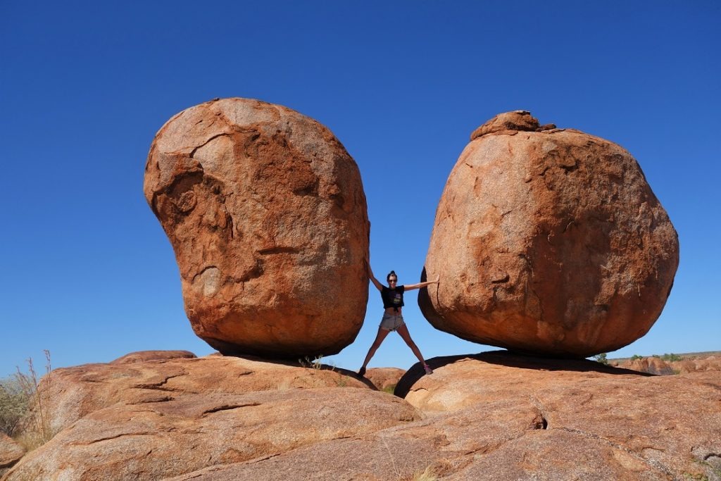standing in between 2 giant rocks, australia