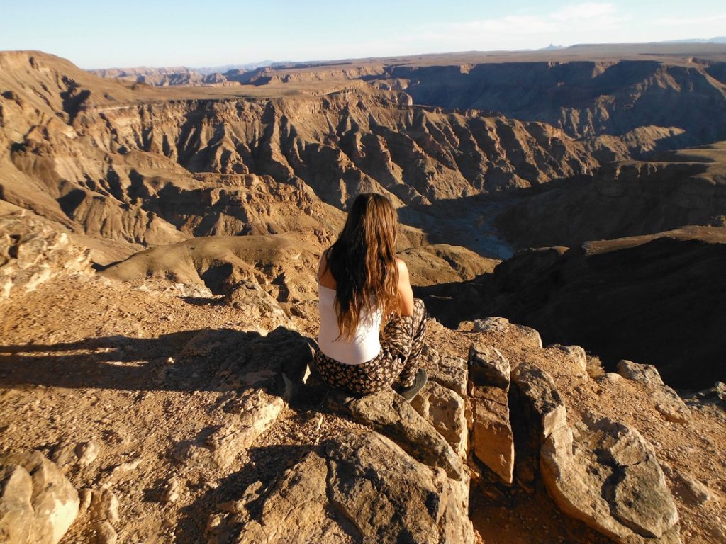 sitting on top of a canyon in namibia