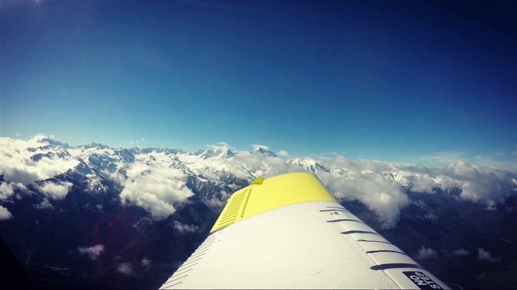aeroplane wing over snow-capped mountains