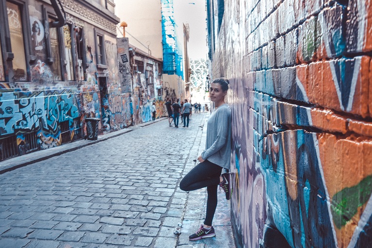 solo female traveller standing on graffiti wall