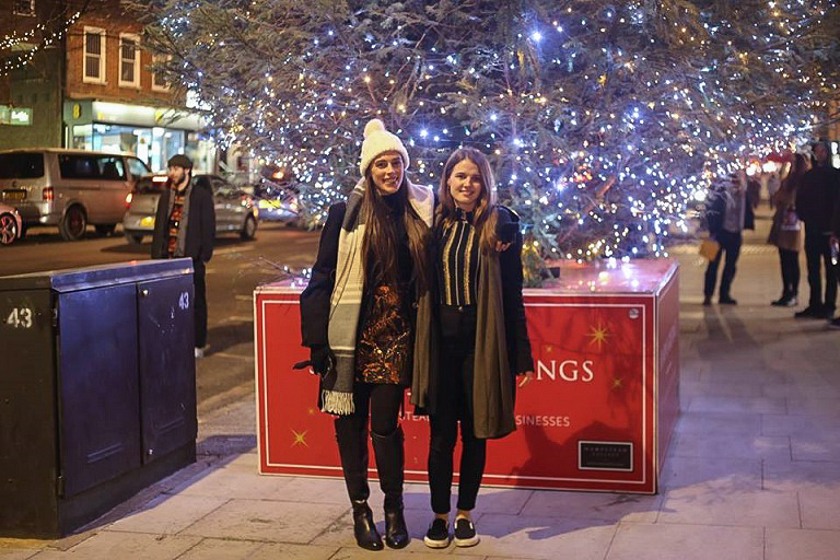 friends posing by a lighted tree