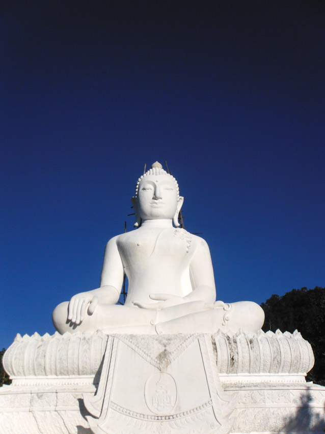 white Buddha statue against blue sky