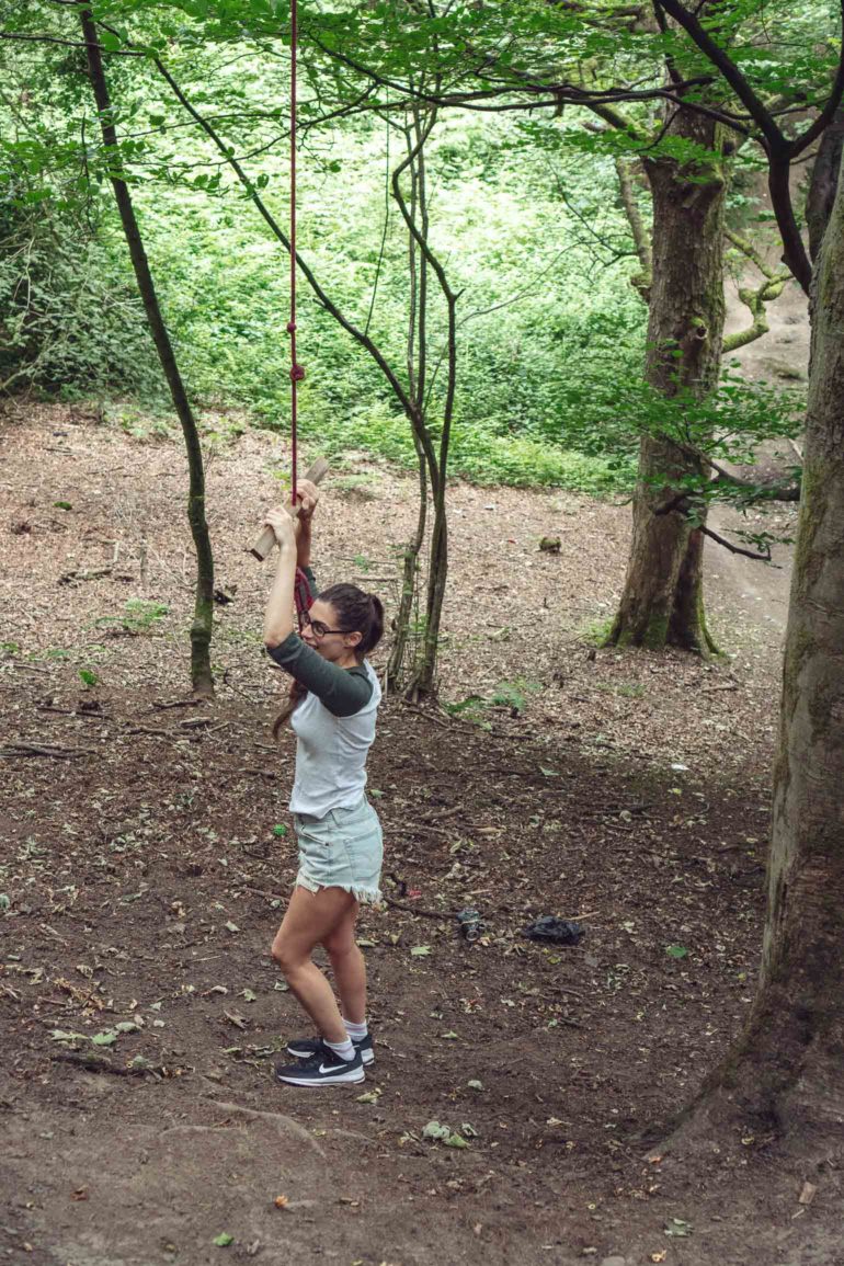 in the woods on a rope swing