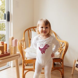 toddler wearing pink dino baby bodysuit